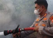 Kapolres Luwu Timur AKBP Irwan Pegang Alat Semprot Bantu Damkar Padamkan Kebakaran Lahan